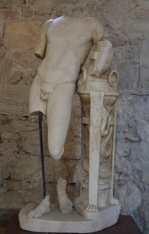 Marble statue of Pythian Apollo leaning on the Delphic tripod encoiled with a serpent and holding Apollo's tortoise shell lyre.