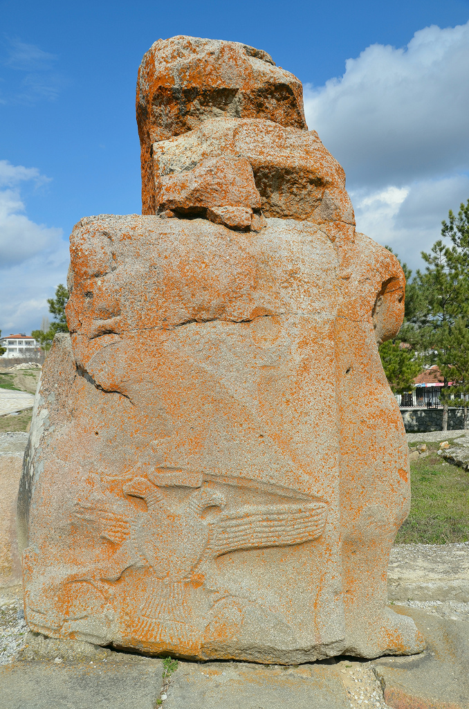 The inner face of the eastern sphinx protome decorated with a double-headed eagle engraved as a low relief, over the eagle, legs of a goddess walking towards the city can be seen.