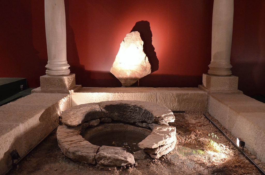 Stone water basin protected with a wooden roof supported by four columns.