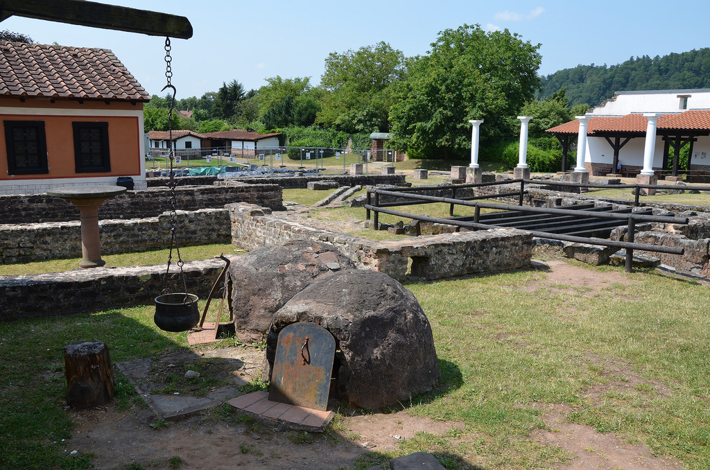Rear view of the partially reconstructed house. The ditch is a drainage channel. The painted wing of the building is the reconstructed dining area of the house.