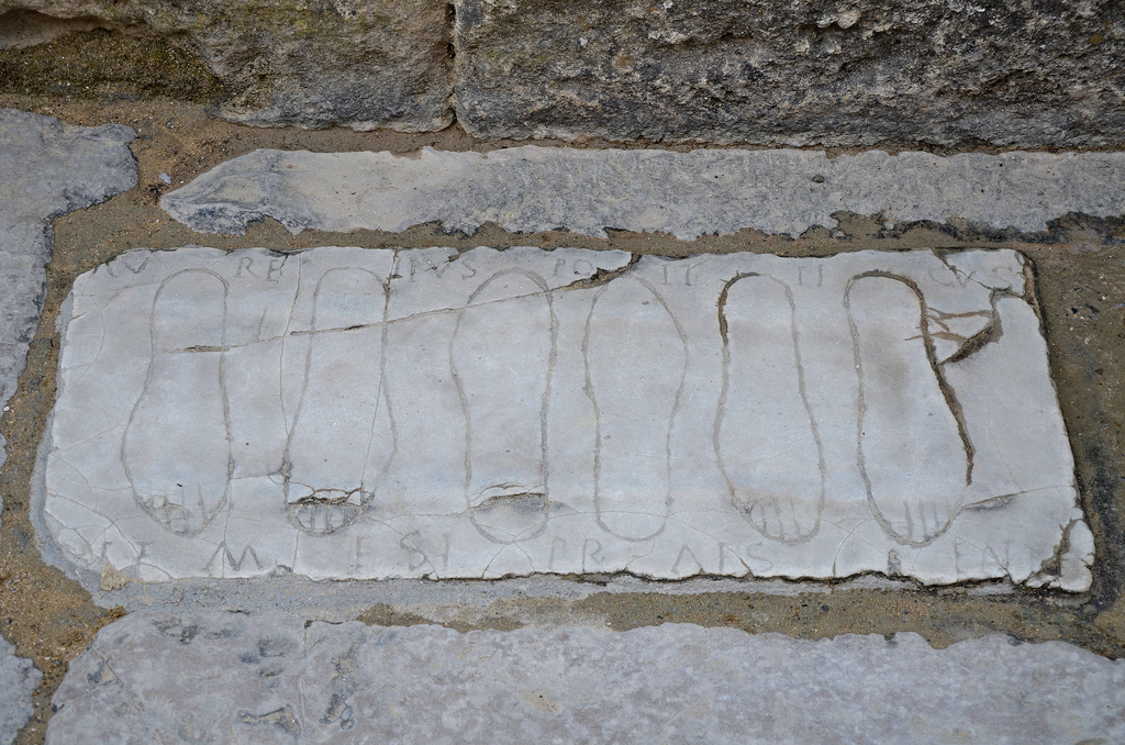 Votive plaque with engraved footprints at the entrance of the Roman amphitheatre.