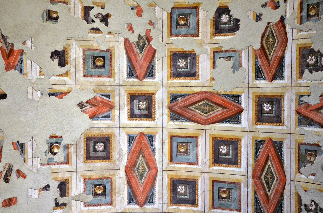 The ceiling is decorated with a painted pattern of rhomboidal and square coffers containing rosettes, whose relief was suggested by the use of shading as well as by means of perspective. The frames were rendered in shades of red, yellow and white, the inner moulding in orange, yellow, blue and green, and ornaments of the coffers in purple, black, white and yellow.